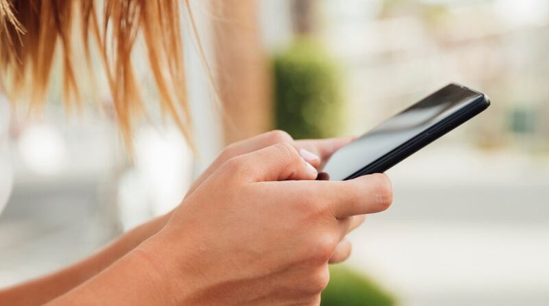 Mujer joven con smartphone negro