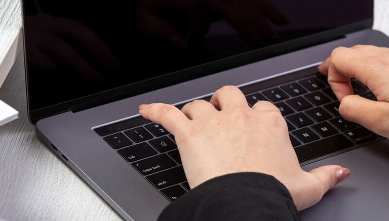 Una chica de vista frontal usando una computadora portátil frente a la mesa usando una actividad comercial