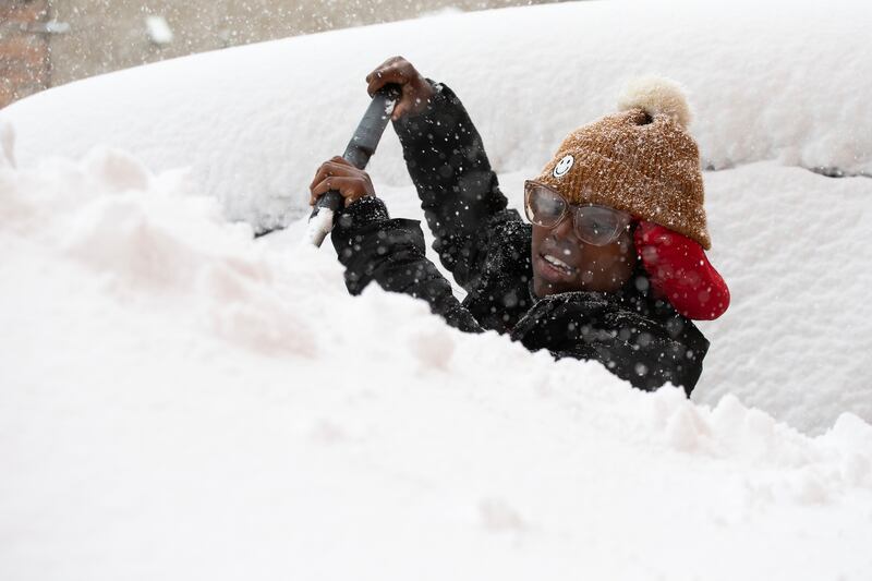 Zaria Black, de Buffalo, quita la nieve de su auto en Buffalo, Nueva York, EEUU, viernes 18 de noviembre de 2022.