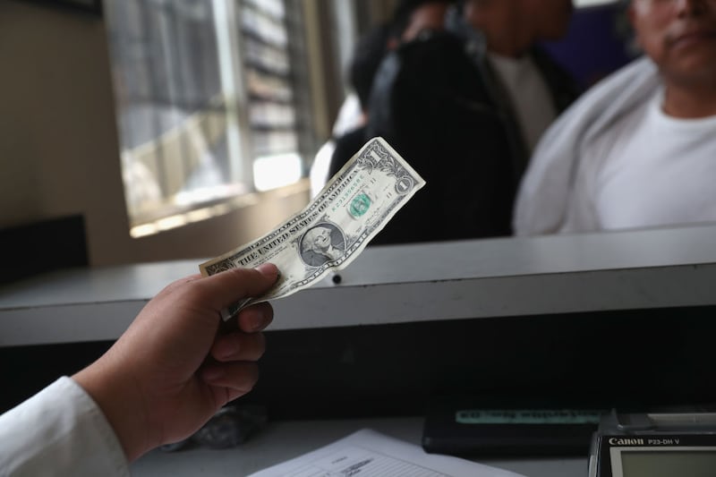 GUATEMALA CITY, GUATEMALA - FEBRUARY 09: An immigration official changes a deported immigrant's single dollar into Guatemalan Quetzales after the arrival of an ICE deportation flight on February 9, 2017 to Guatemala City, Guatemala. The charter jet, carrying 135 deportees, arrived from Texas, where U.S. border agents catch the largest number illigal immigrants crossing into the United States, many of them from Central America. The Guatemalan Exterior Ministry gives the deportees phone calls to their family, lunch and a ride to their towns upon their return. U.S. President Donald Trump pledged to vastly increase the number of deportations as part of his platform to crack down on illegal immigration.