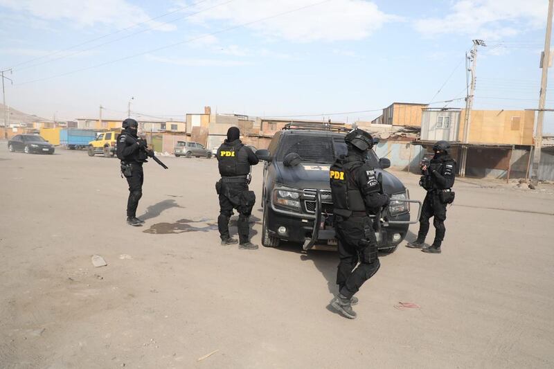 Mega operativo en Arica
Más de 250 detectives participaron del operativo que busca desarticular nuevas facciones de Los Gallegos y otras redes criminales que operan en el lugar . Se allanaron simultáneamente 37 inmuebles en el sector, además de siete cárceles del país donde permanecen recluidos los miembros de esta agrupación criminal.
En medio del juicio oral que se sigue en contra de 38 miembros de Los Gallegos, la Fiscalía de Arica y la Brigada Antinarcóticos y Contra el Crimen Organizado de la PDI Arica asestaron un nuevo y fuerte golpe contra el crimen organizado, al llevar a cabo, esta mañana un nuevo megaoperativo denominado Tren del Norte IV en el sector de Cerro Chuño, en el marco de la investigación por delitos vinculados al crimen organizado.
En las diligencias participaron más de 250 funcionarios policiales de Arica y otras regiones, quienes hicieron ingreso a 37 inmuebles en Cerro Chuño, apoyados por equipos tecnológicos como drones, entre otros elementos, operativo en el que se logró la detención de imputados en flagrancia, además de la incautación de drogas, armas y municiones, entre otras evidencias.
La diligencia además incluyó un operativo de allanamiento simultáneo, por parte de personal especializado de Gendarmería, en las siete cárceles del país donde permanecen recluidos los miembros de esta agrupación criminal, que son las de Arica (2), La Serena, Valparaíso, Cárcel de Alta Seguridad en Santiago, Rancagua y Biobío.
El operativo en los recintos penitenciarios permitió incautar 7 teléfonos celulares, documentos, armas blancas y una llave de esposas desde el interior de una celda de la cárcel de alta seguridad en Santiago, donde permanecen los cabecillas de Los Gallegos.