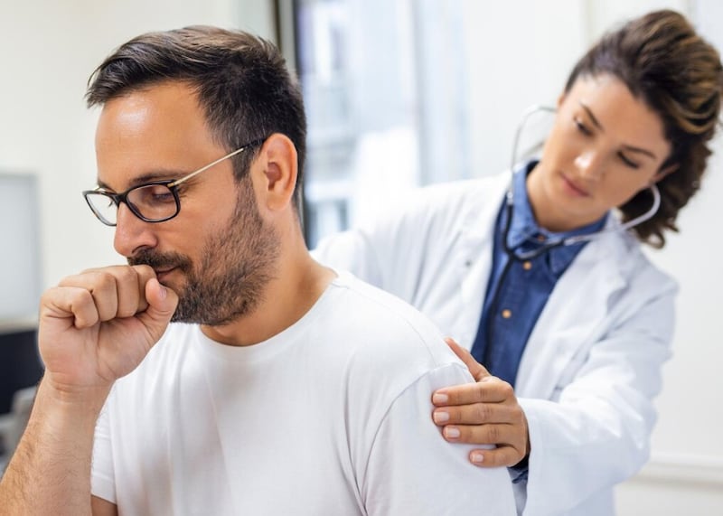 Una doctora en la clínica realiza la auscultación de los pulmones de un paciente con síntomas de coronavirus o neumonía